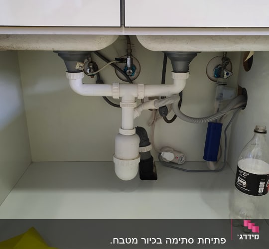 צנרת מתחת לכיור עם מחברים וברזים